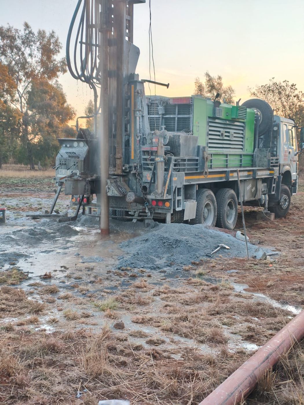 Drilling truck and rig at sunset