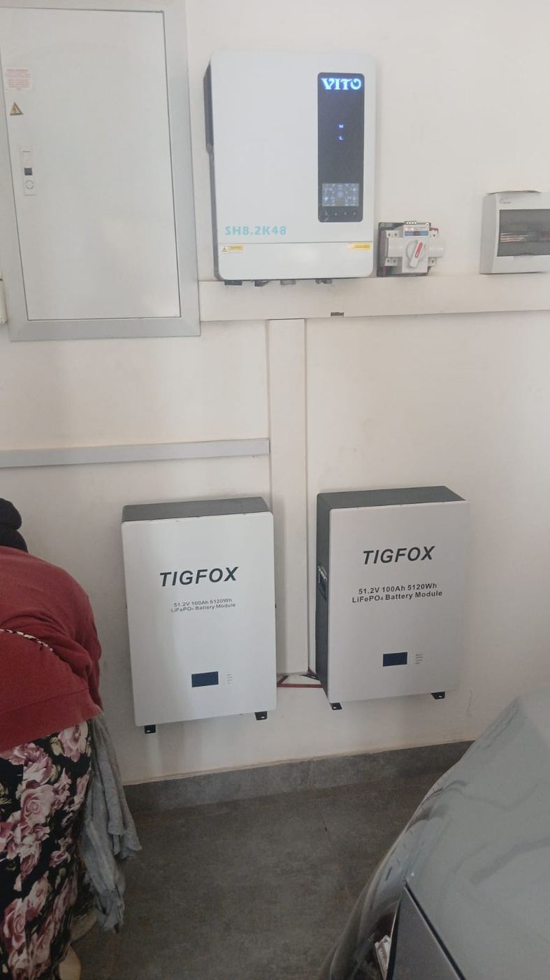 Two wall-mounted batteries beside an inverter