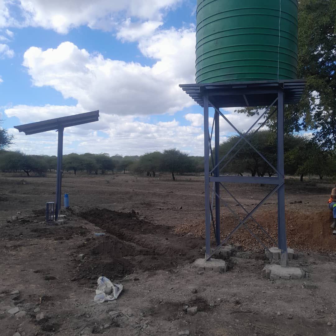 Solar panel stand beside an elevated green water tank